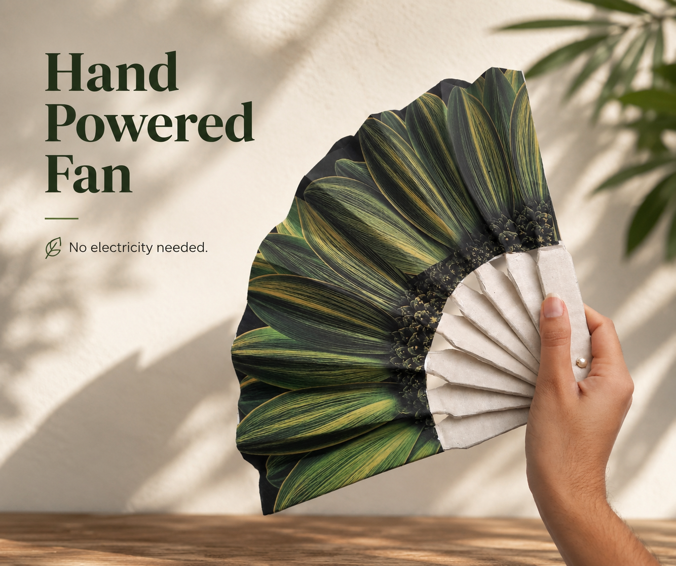 Graphic reading ‘Hand Powered Fan’ beside a hand holding an open green botanical folding fan