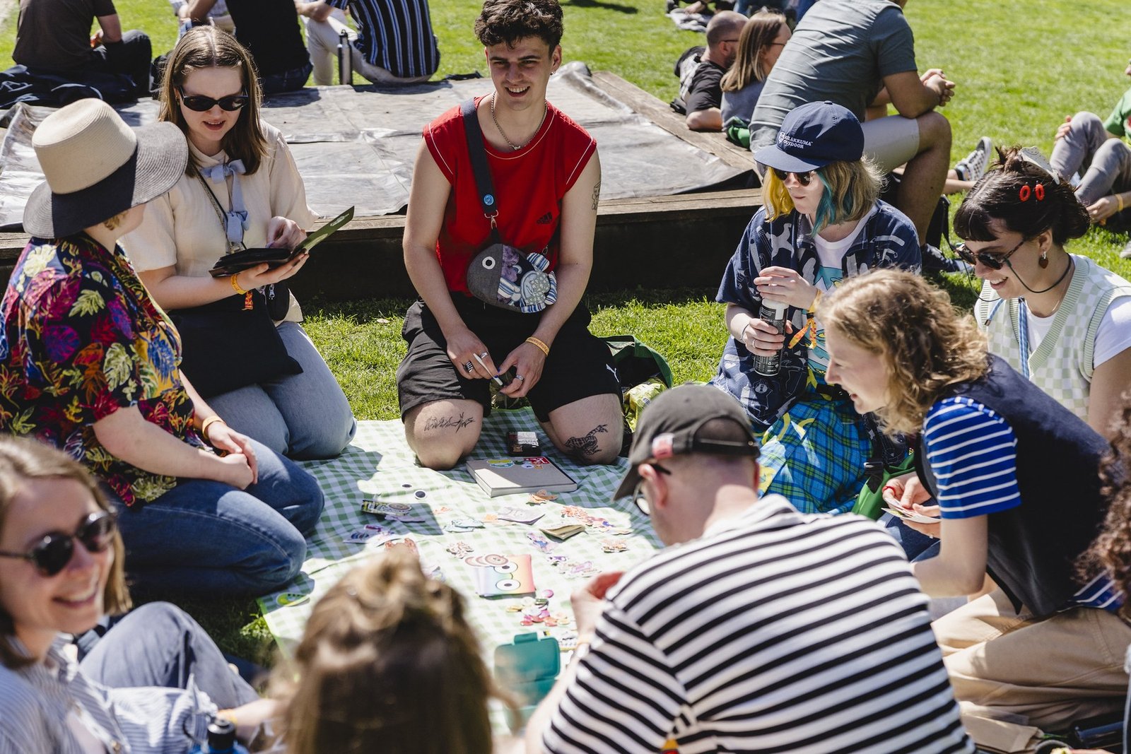 Visitors sitting together on the green at Pictoplasma