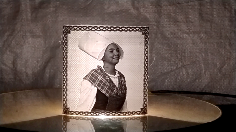 Illuminated 3D-printed lithophane portrait in a decorative frame on a round table