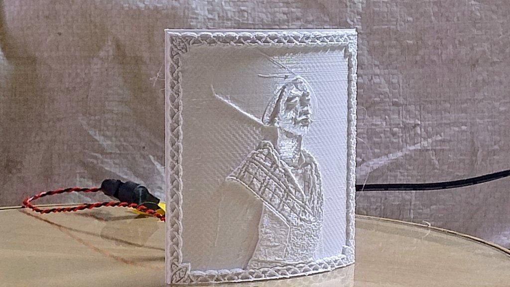 Unlit white lithophane portrait panel standing upright with wiring behind it