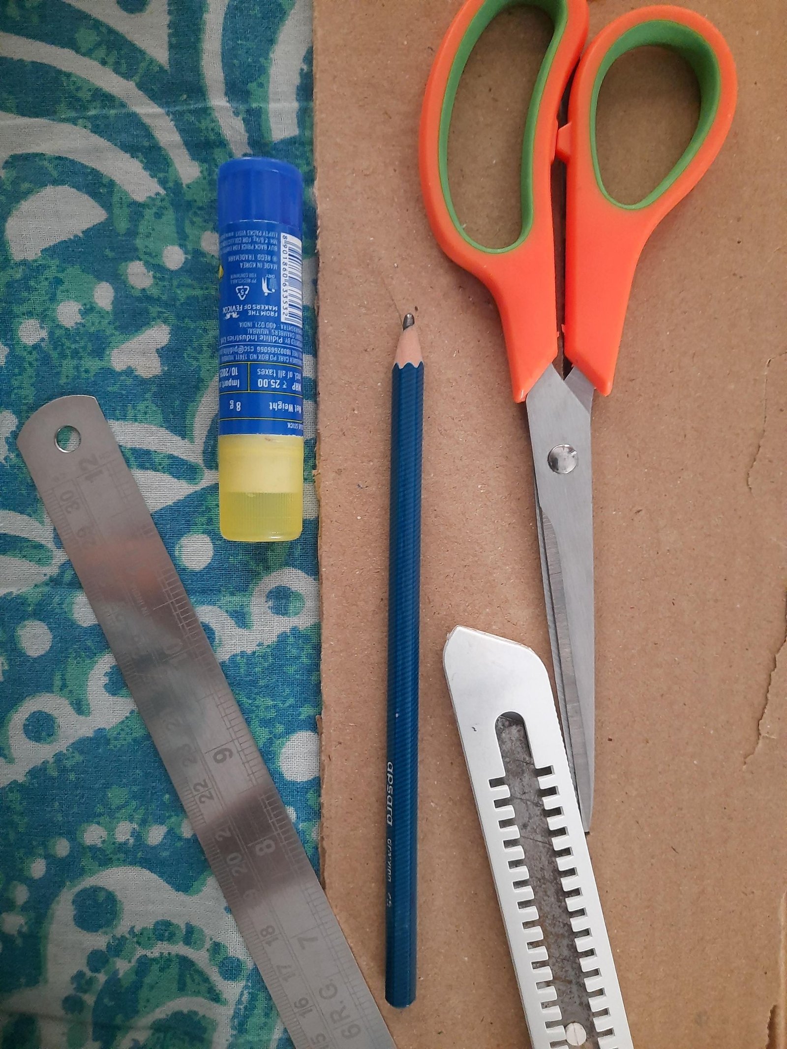 Cardboard, paper, glue, scissors, ruler, pencil, and craft knife for making the fan
