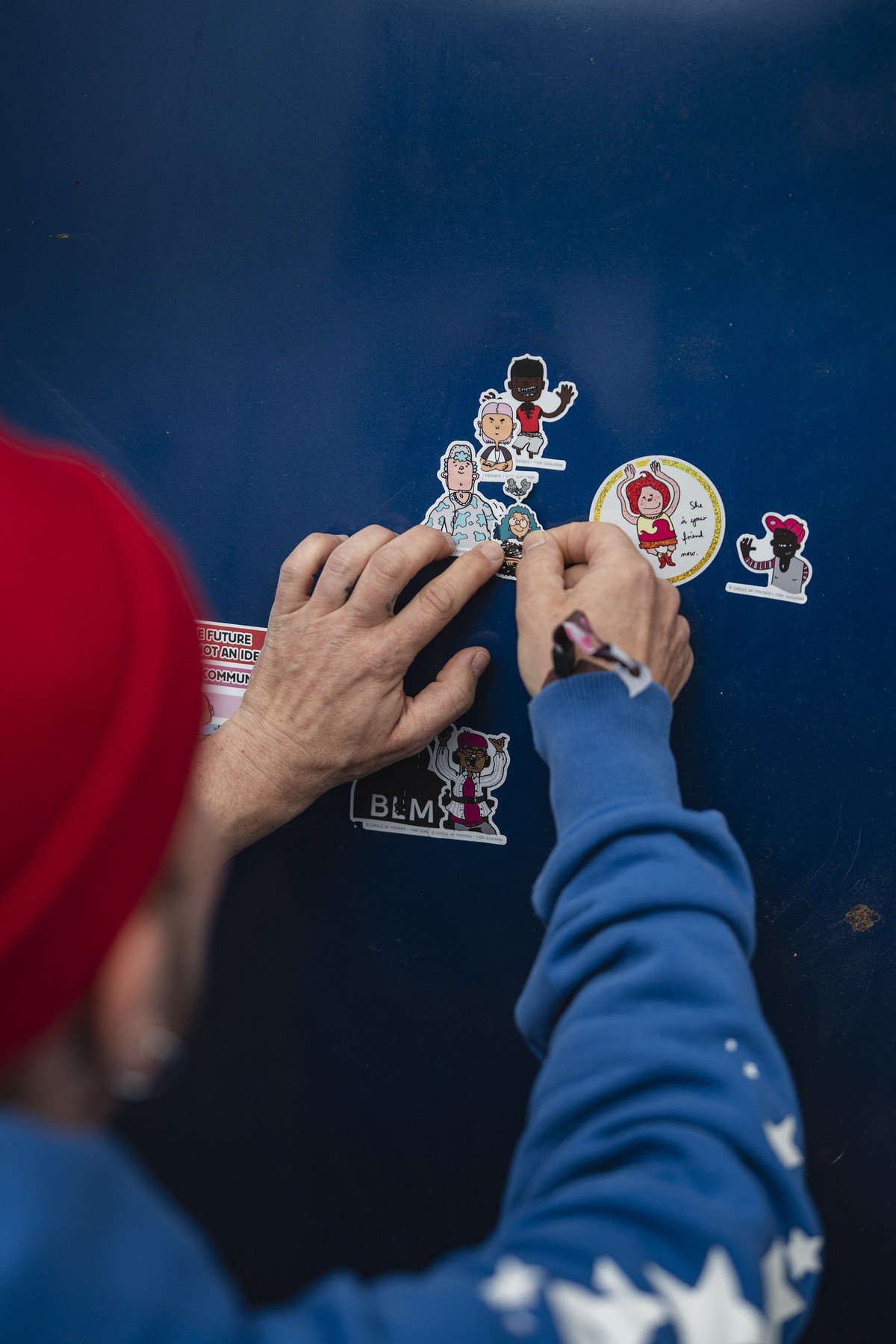 Hands arranging character stickers and badges at Pictoplasma