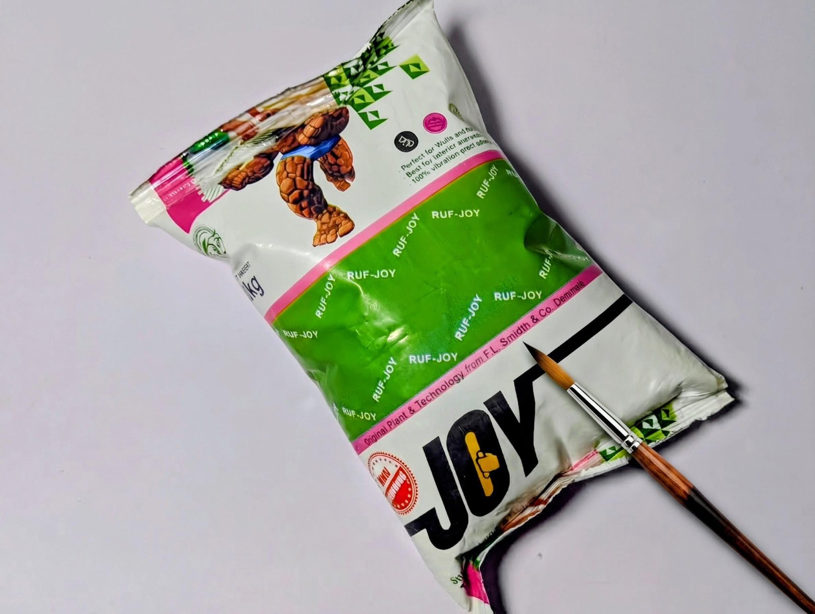 Bag of cement with a small brush resting across the package