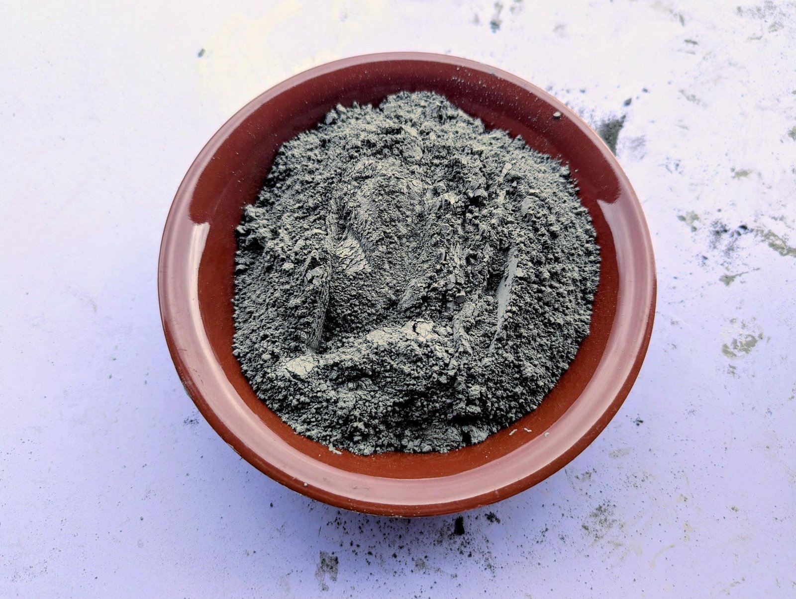 Dry cement powder measured into a shallow bowl