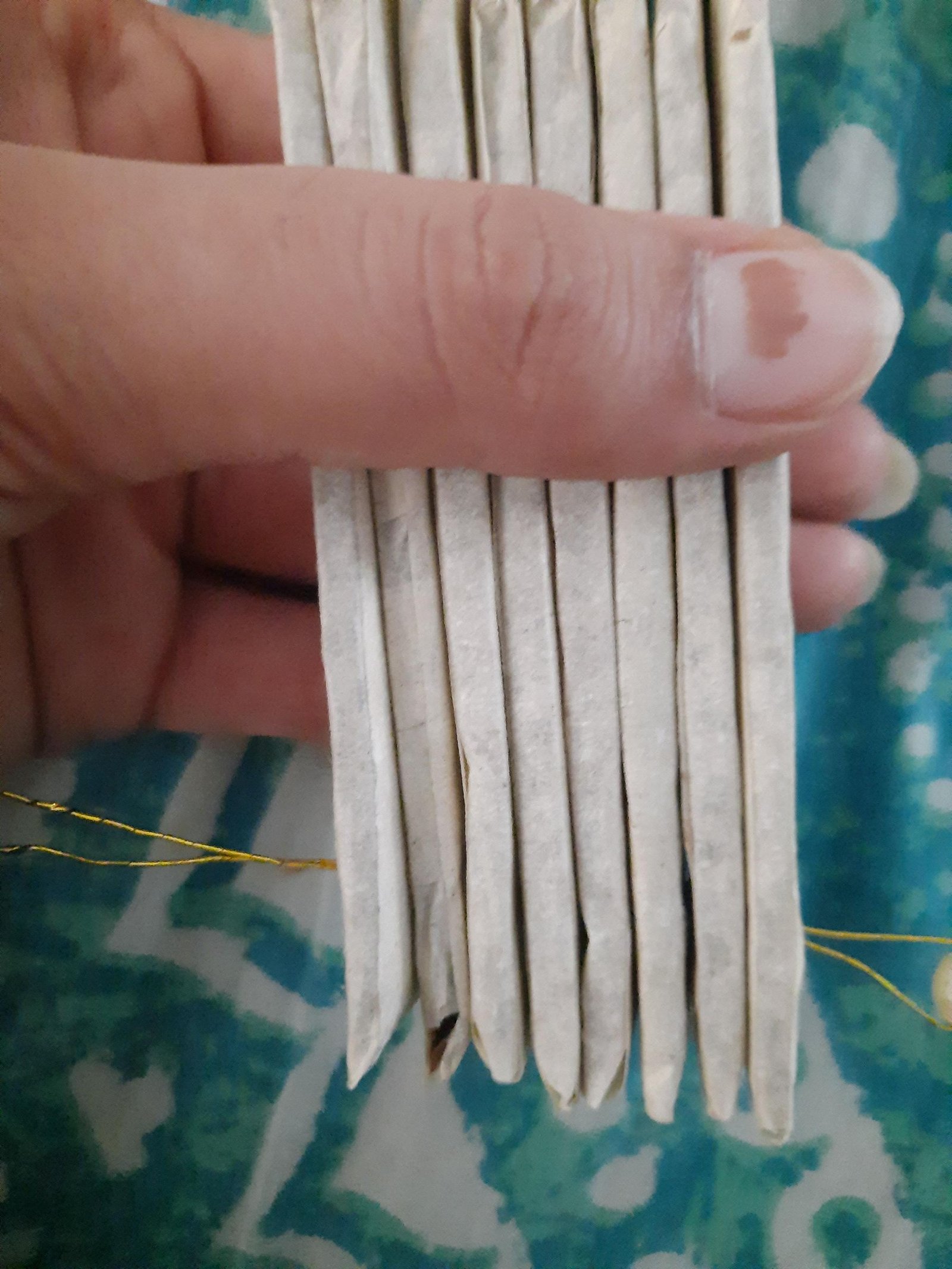 Stacked paper-covered fan ribs held together at their aligned lower pivot holes