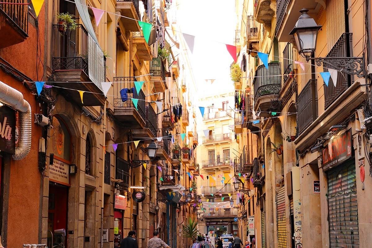 Narrow Barcelona old-town street lined with traditional buildings and flags