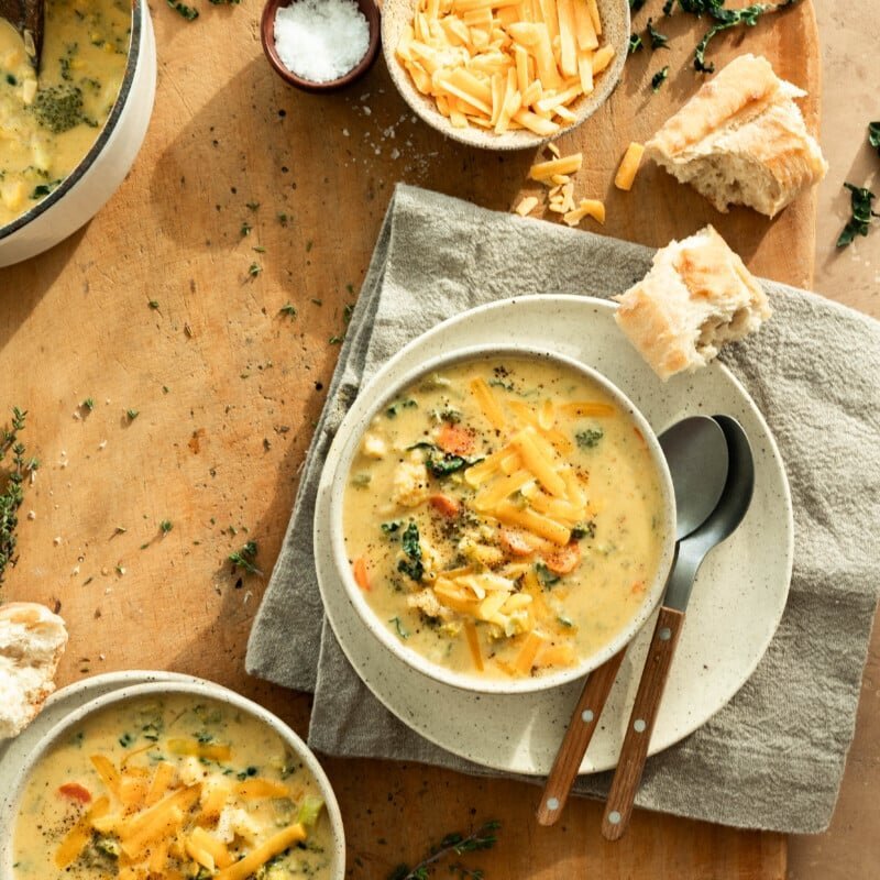 Bowls of creamy broccoli cheddar soup arranged for a gathering