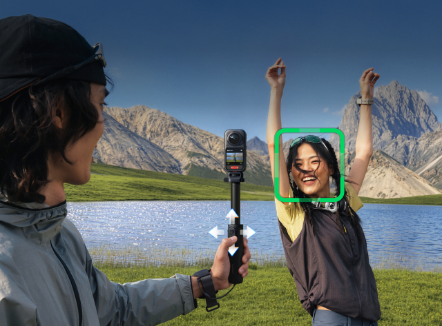 Person filming a woman with an Insta360 X6 beside a mountain lake