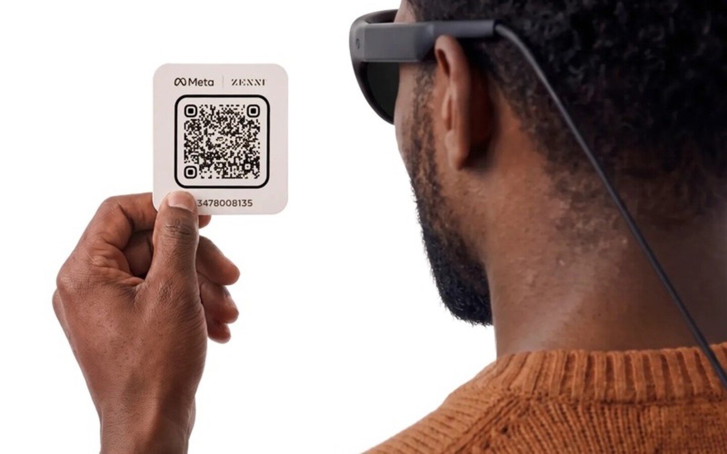 A person wearing Project Phoenix glasses while holding a Meta and Zenni QR card