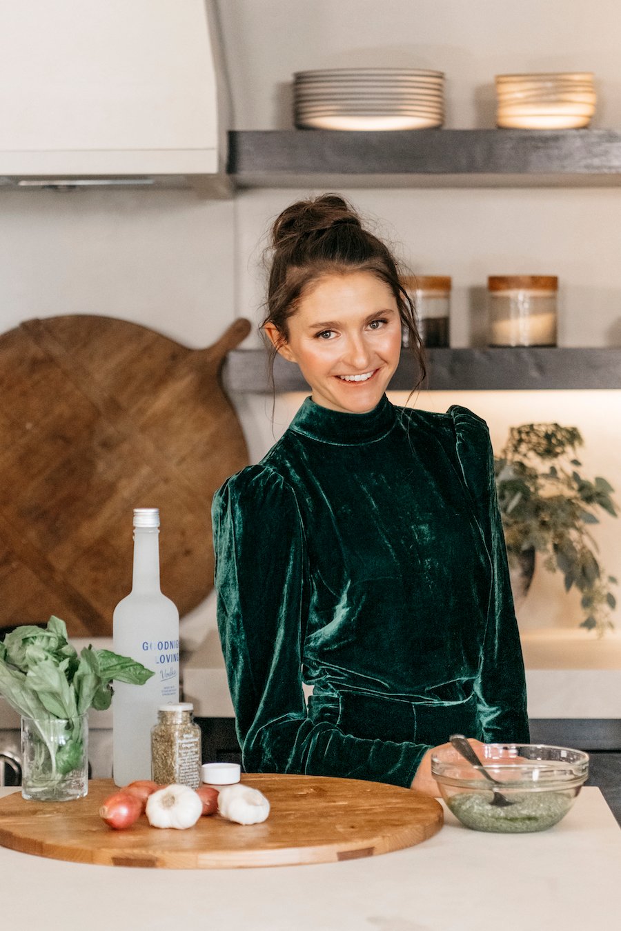 Tieghan Gerard in her kitchen with ingredients for pesto pasta alla vodka