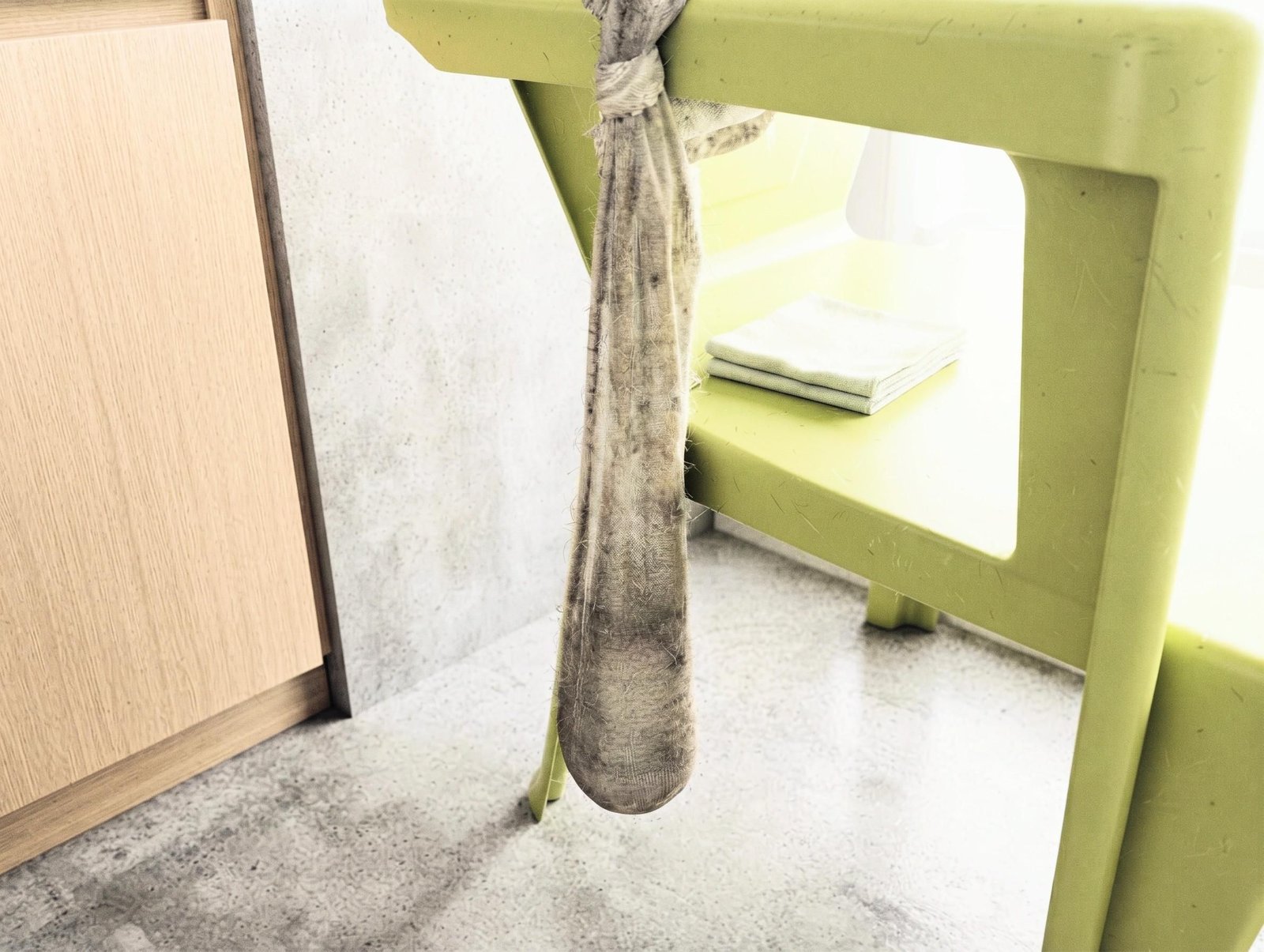 Sock filled with wet cement and suspended from a chair while the stem cures