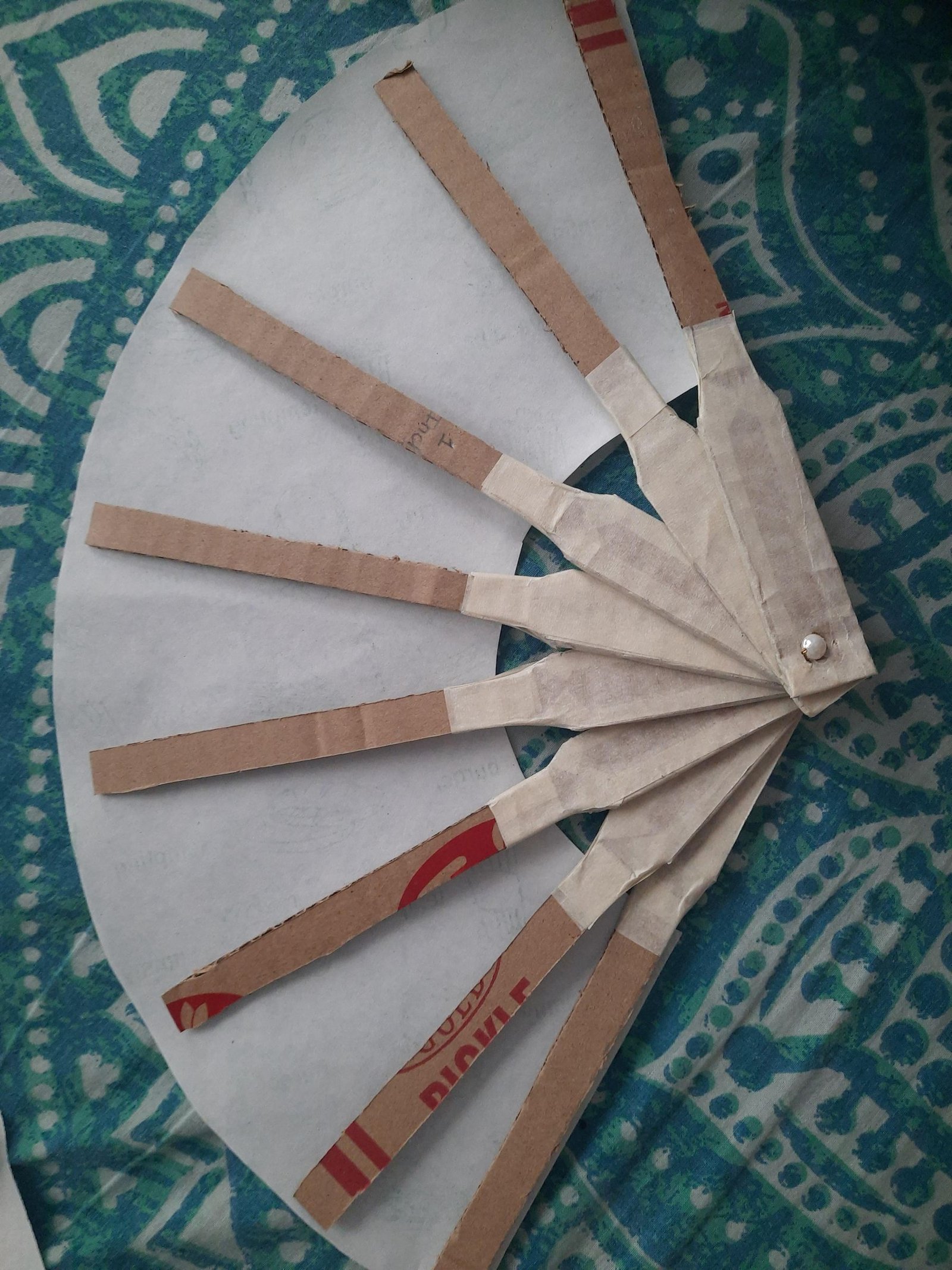 Cardboard ribs spaced across the back of a fan-shaped paper sheet