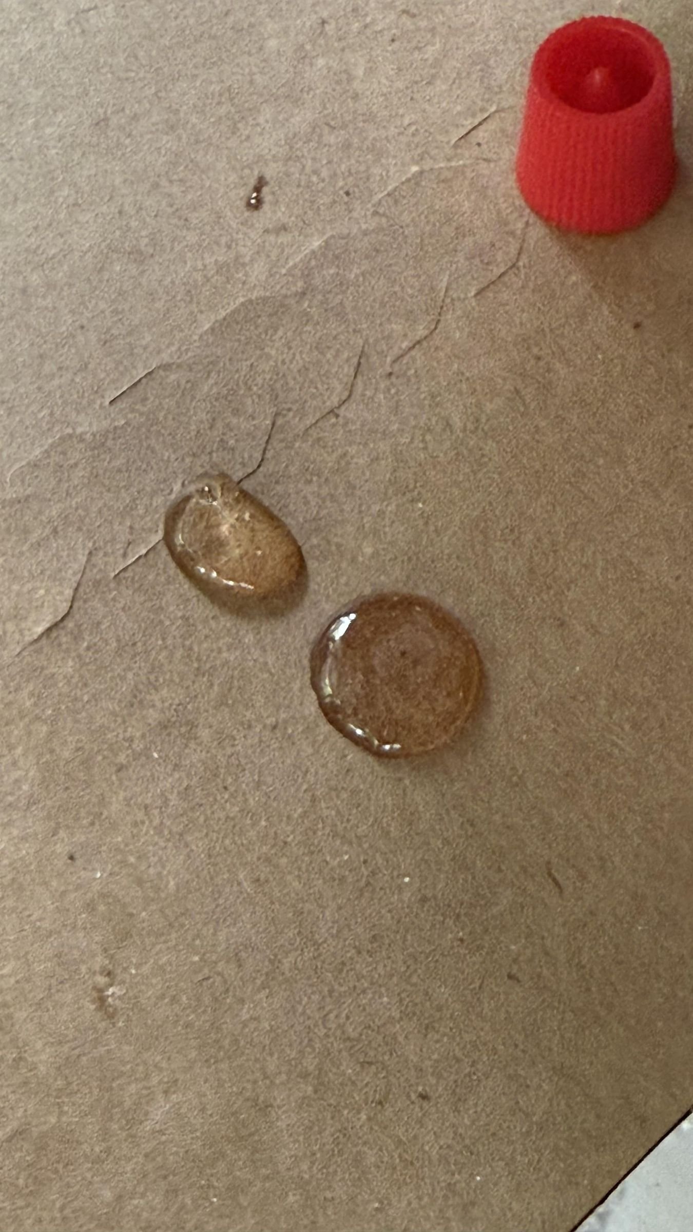 Two equal drops of epoxy components placed on scrap card for mixing