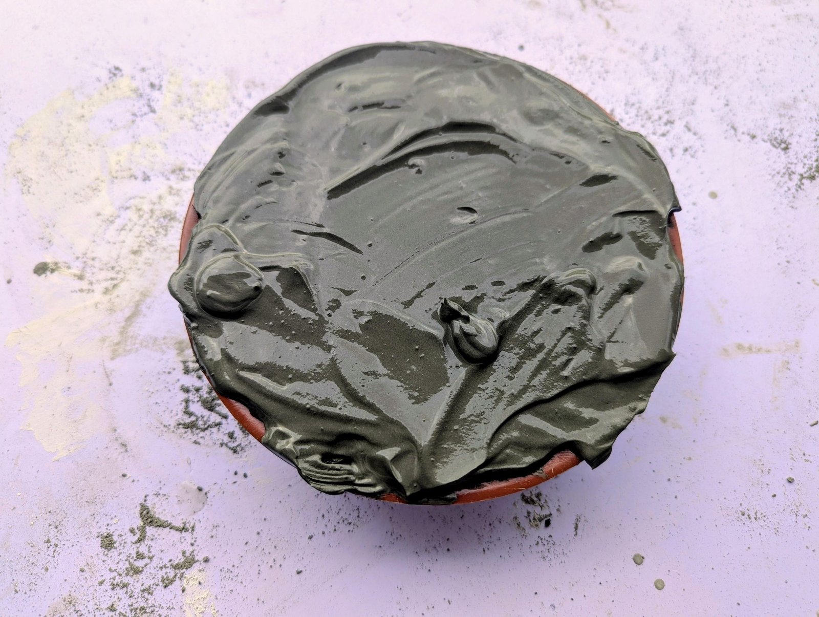 Shallow plate filled to the rim with wet cement for the mushroom cap
