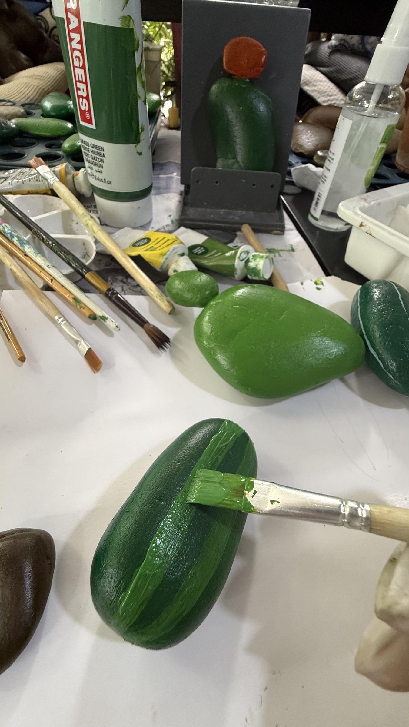 A brush adding lighter green ridge stripes to a dark green cactus stone