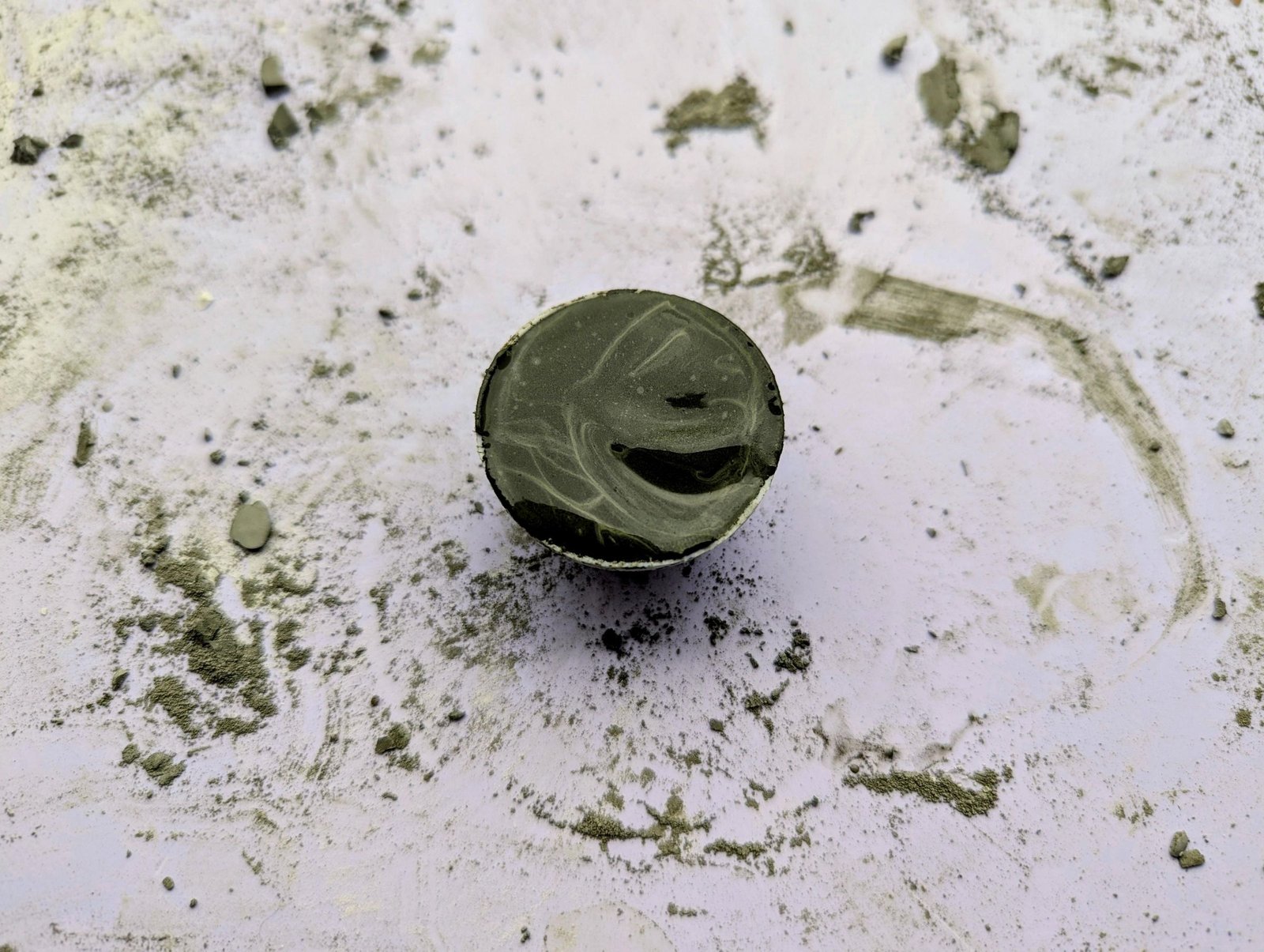 Half a ping-pong ball filled with wet cement for a small cap