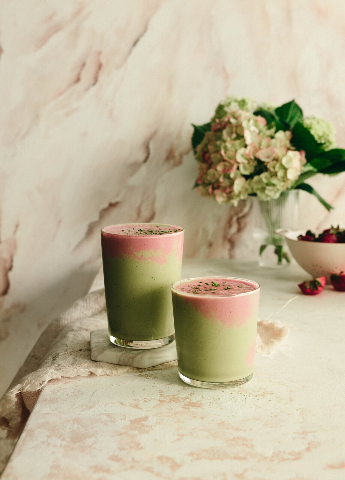 Green matcha smoothies topped with a pink strawberry blend