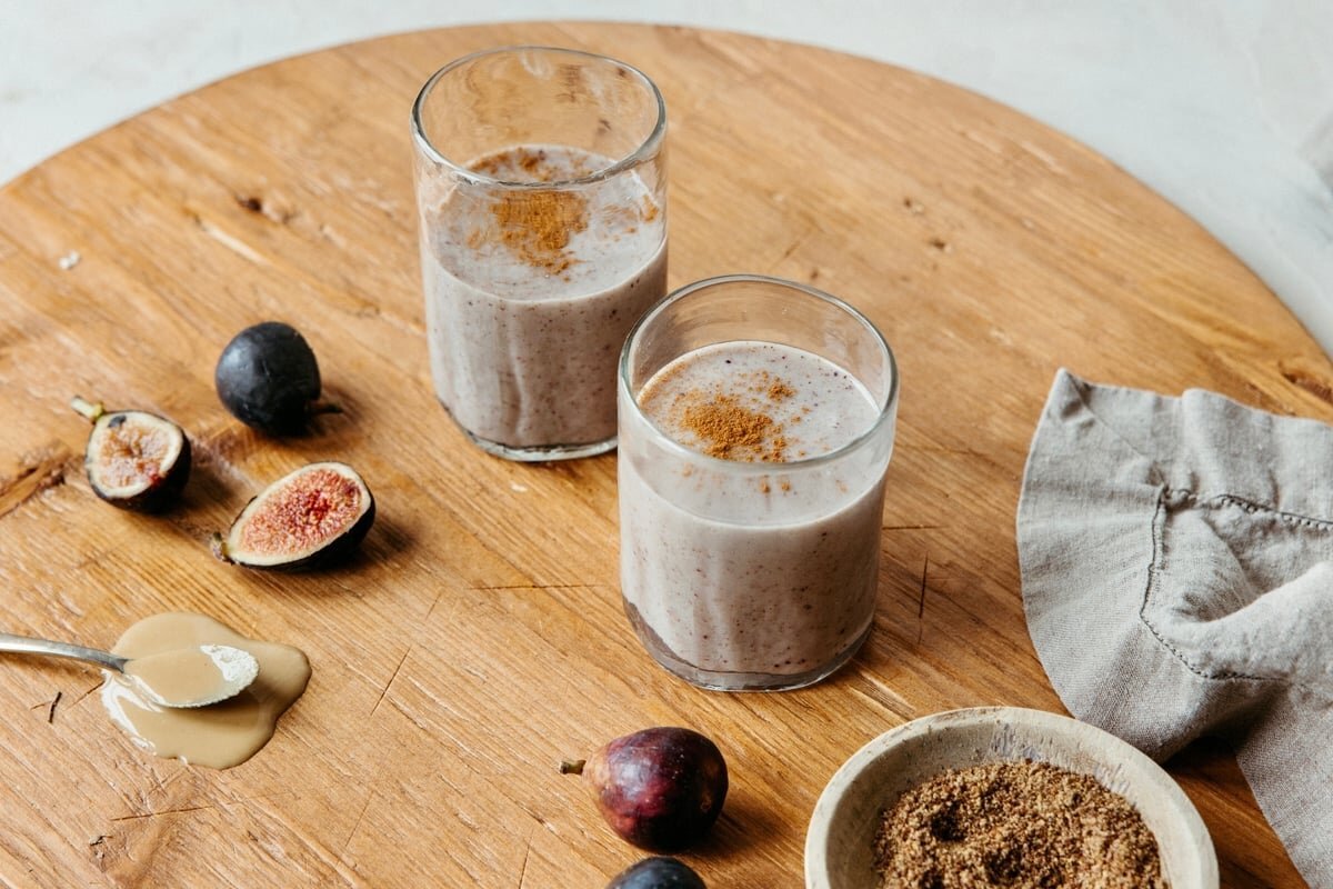 Creamy fig smoothies served with fresh figs, tahini, and flaxseed