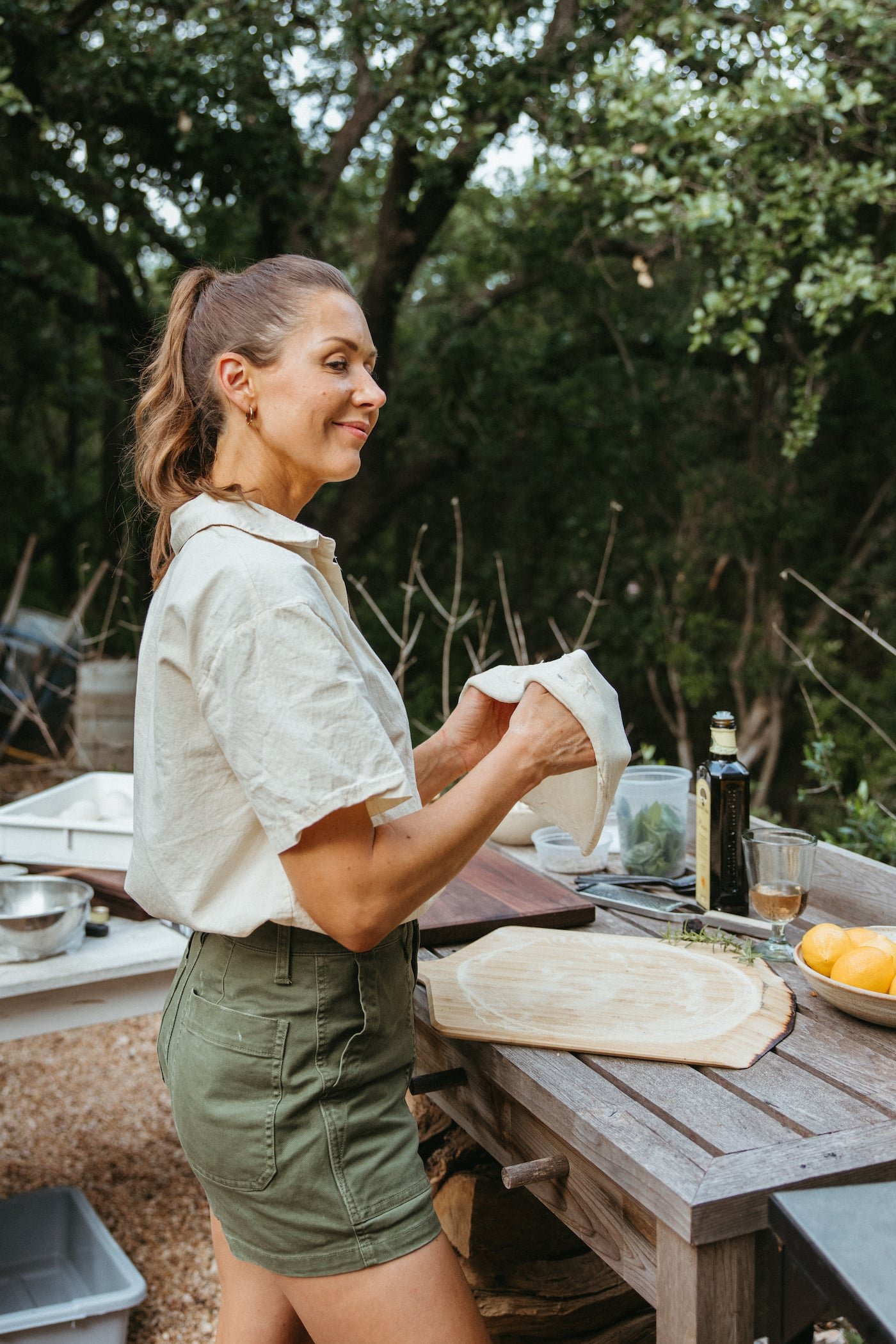 A host preparing an outdoor pizza-making station