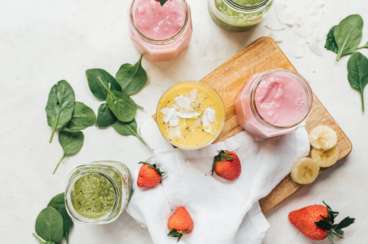 Assorted fruit and green smoothies with spinach, berries, and banana