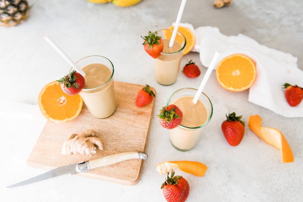 Tropical pineapple ginger smoothies served with strawberries, banana, and citrus
