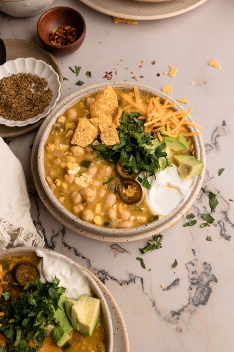 Creamy vegetarian white chickpea chili with avocado and herbs
