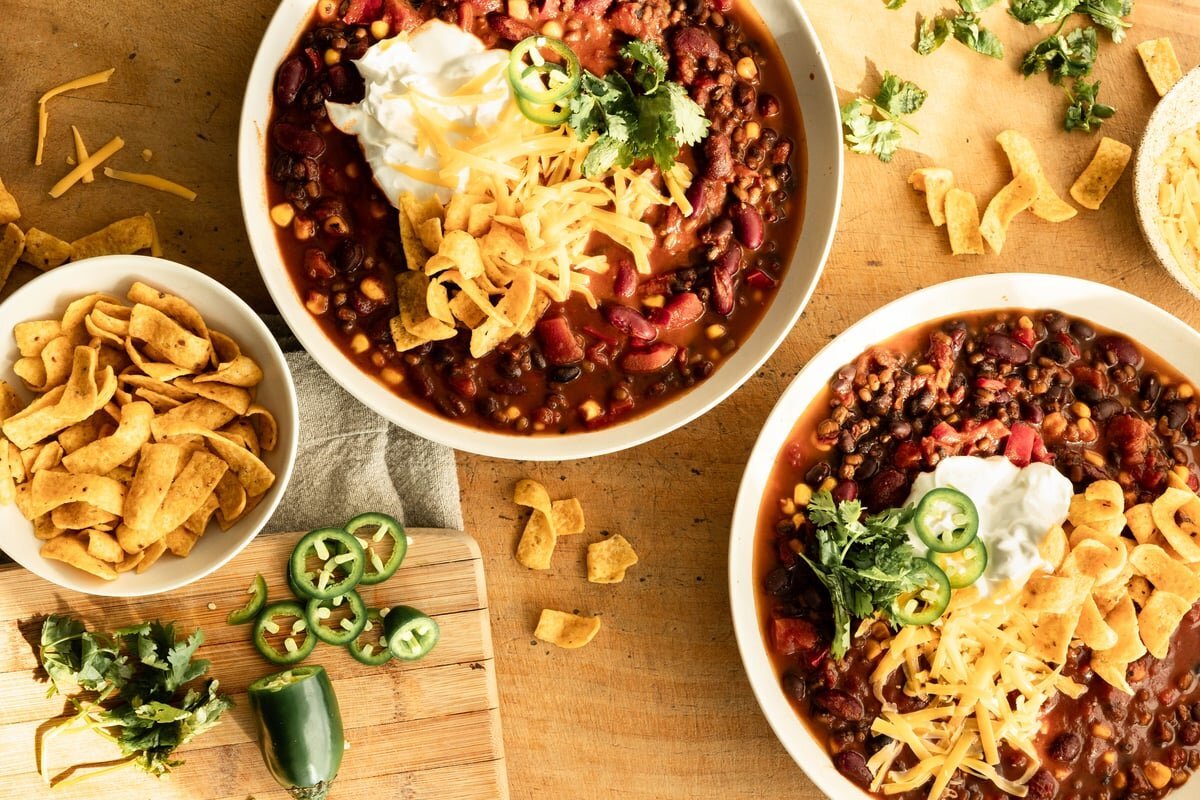 Lentil vegetarian chili with cheese and fresh toppings