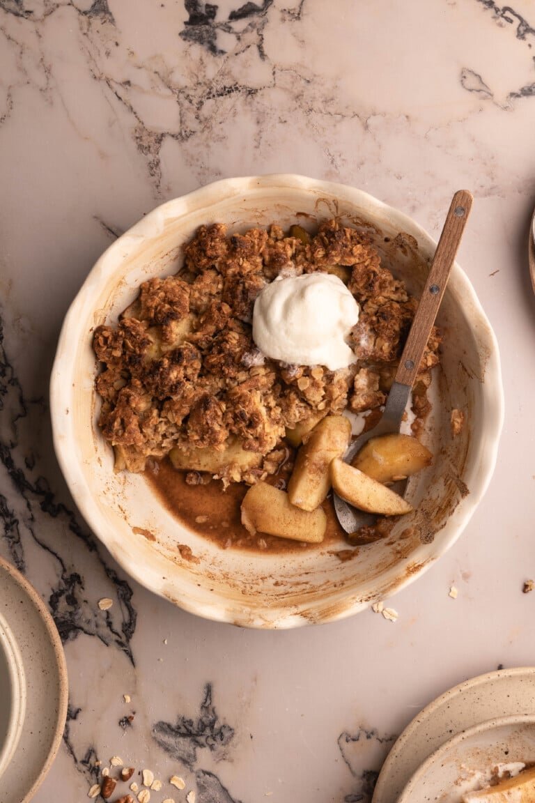 Warm apple crumble in a baking dish with ice cream