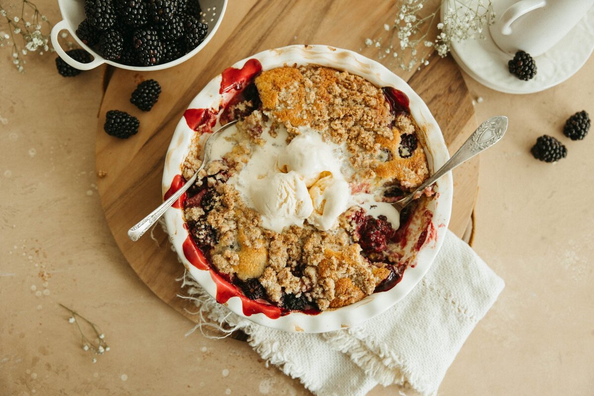 Blackberry cobbler with a golden topping and vanilla ice cream